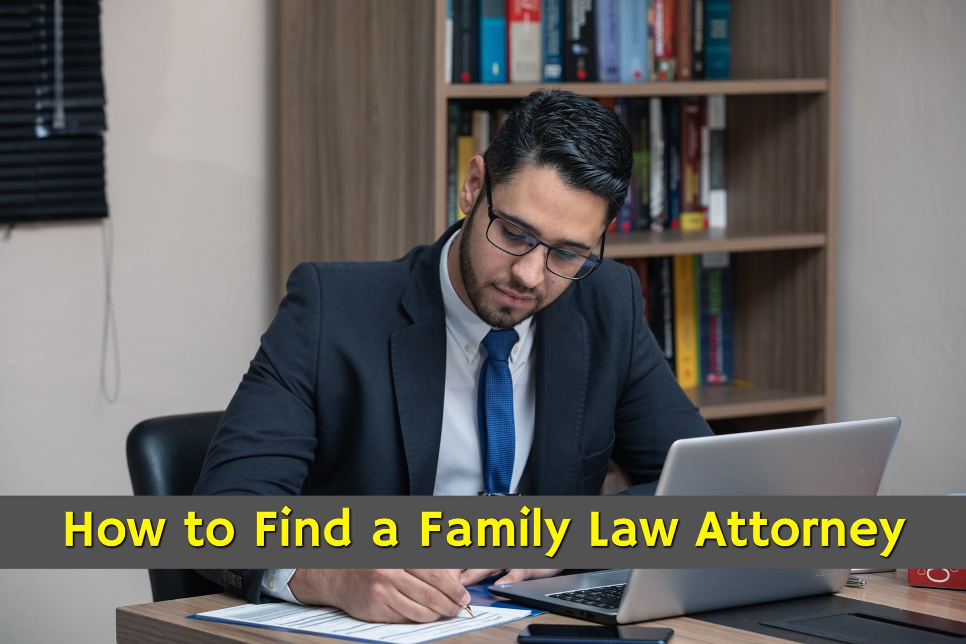 A man sitting at his computer with a notepad researching how to find a family law attorney